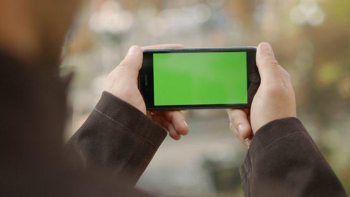 男人使用绿色屏幕的手机