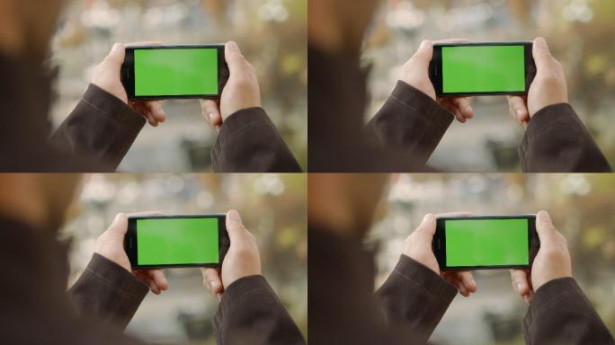 男人使用绿色屏幕的手机