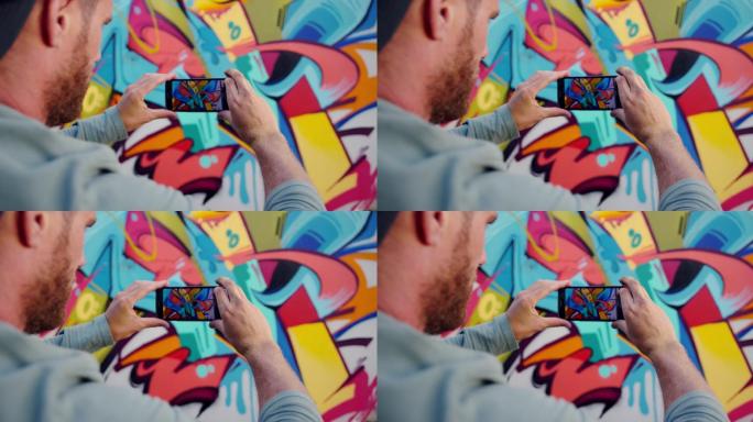 涂鸦艺术家用手机为涂鸦墙拍照
