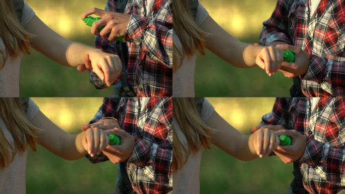 男友在森林里给女友手上喷驱蚊剂