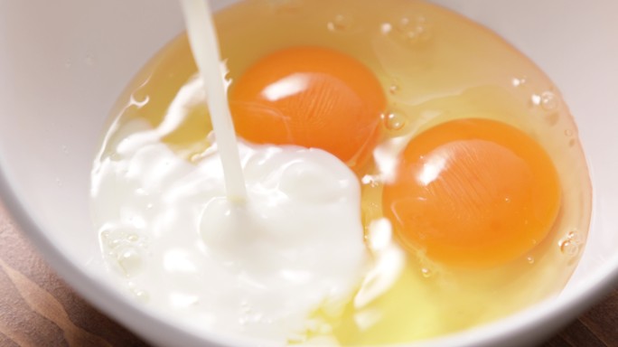 把牛奶倒进一碗生鸡蛋里。