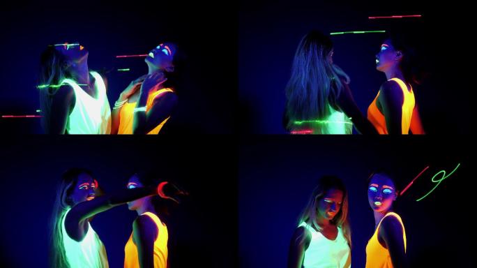 在紫外线黑光下穿着荧光服的两名女子在跳舞