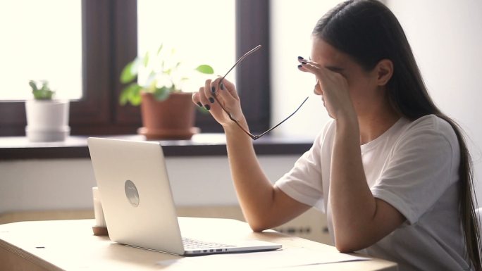 年轻女子在工作时感到眼睛疲劳