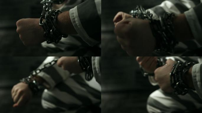 手上戴着铁链的囚犯被关在牢房里