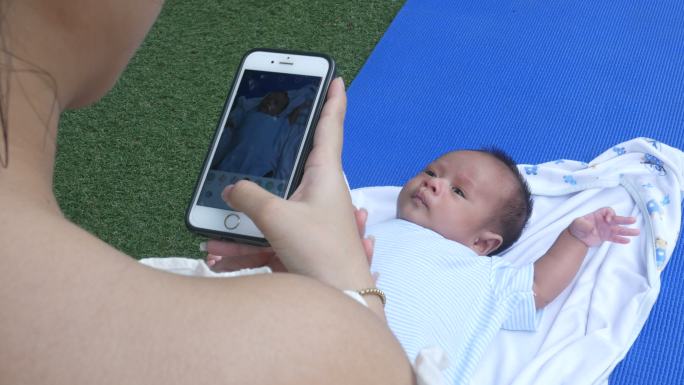 妈妈用智能手机给宝宝拍照