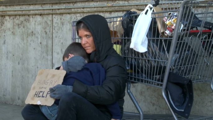 无家可归的女人抱着儿子乞讨