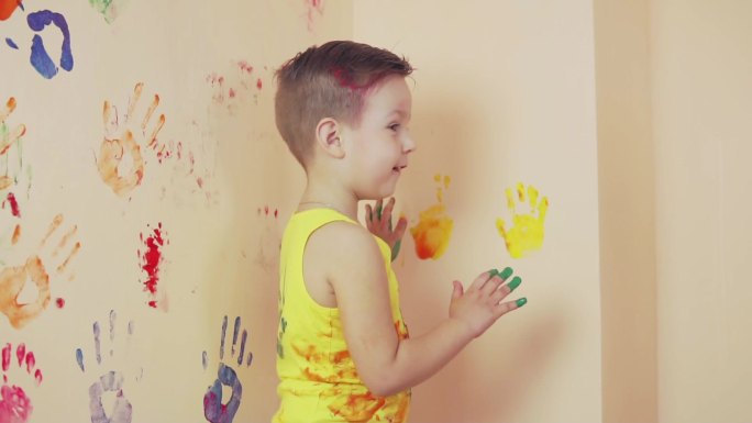 小男孩在墙上留下五颜六色的手印