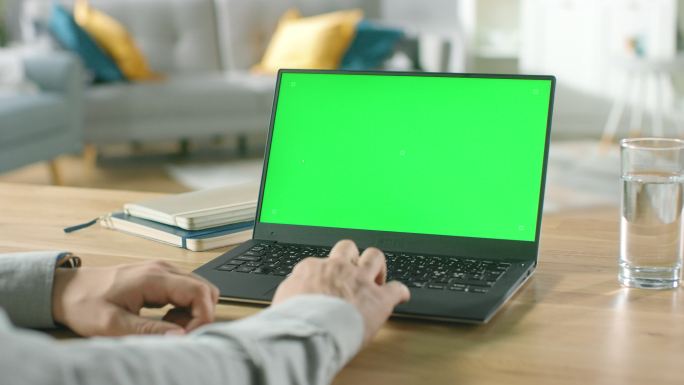 一个男人用带有绿色模拟屏幕的笔记本电脑
