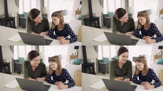 一位母亲在家里帮助女儿做功课时使用笔记本