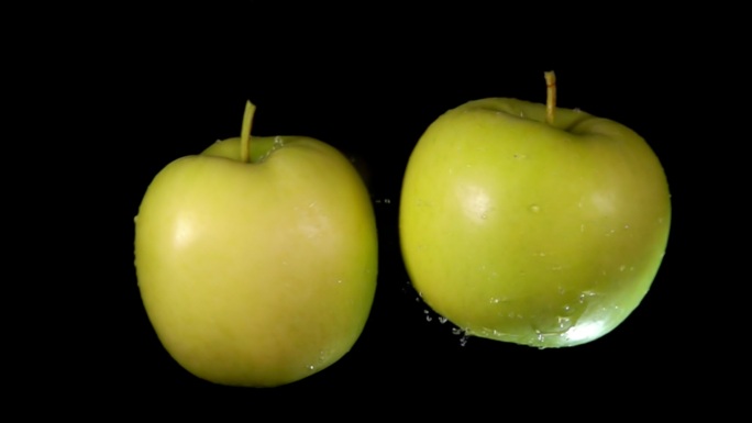 两个湿的青苹果互相碰撞