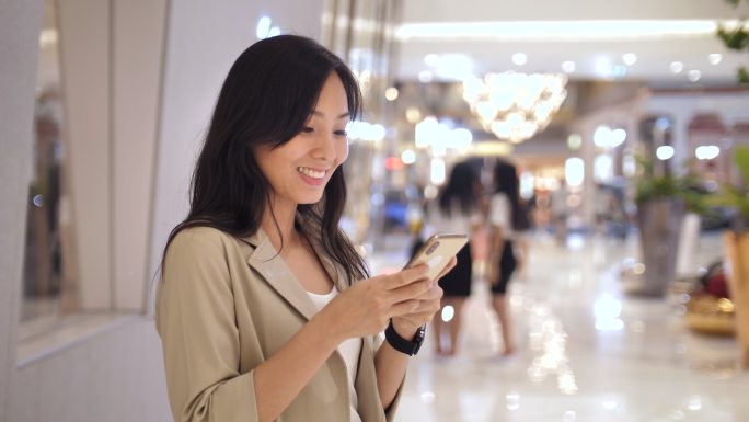 女性在商场使用智能手机