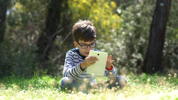 孩子在森林里使用数字平板电脑