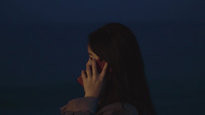 海边夜晚女孩打电话