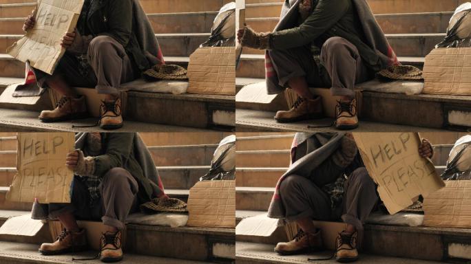 无家可归的老人穿着脏衣服坐在街上寻求帮助