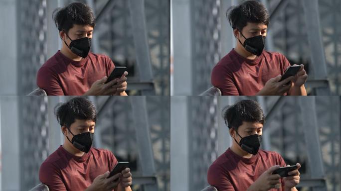 在污染严重的城市戴口罩玩手机的人