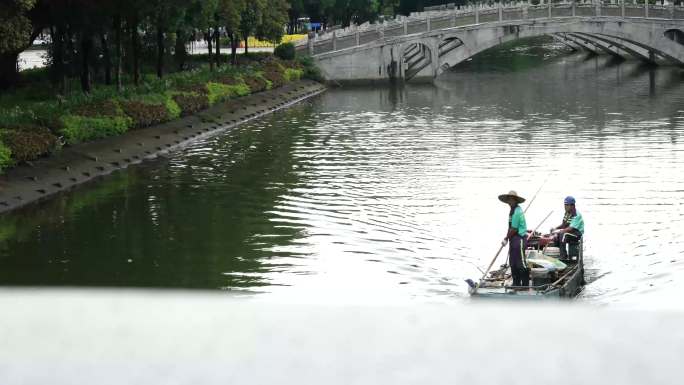 （版权）环卫工人划船清理河道漂浮的垃圾