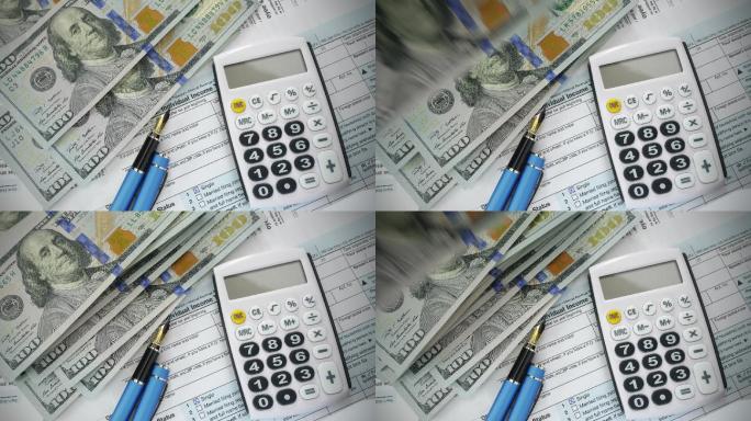 税单，美元钞票，笔，计算器