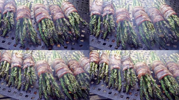 熏肉裹着芦笋放在火热的烤架上