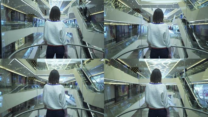 女人爬上购物中心的电梯，从后面看