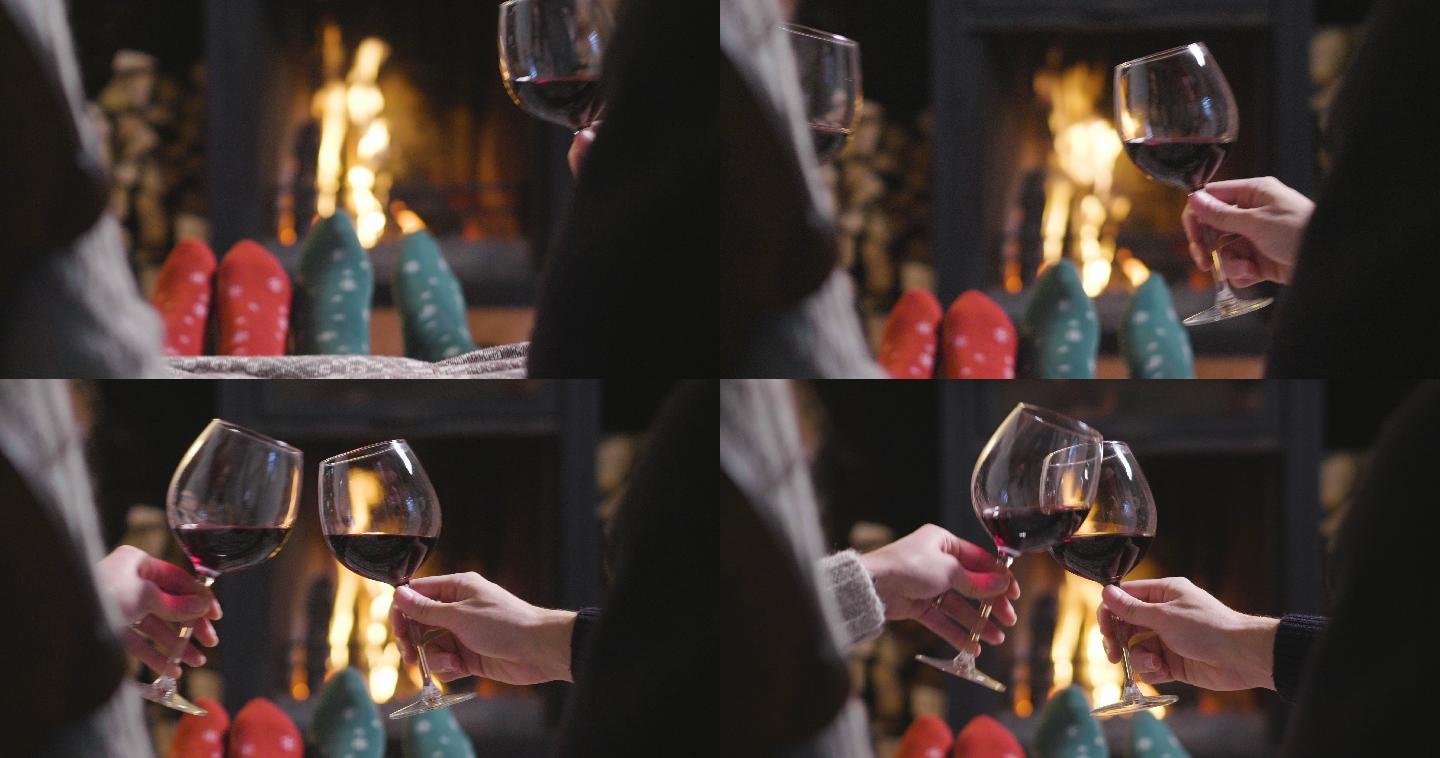 一对夫妇坐在壁炉前喝着葡萄酒