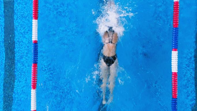 一位女游泳运动员练习蝶泳。