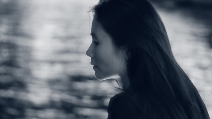 女孩独自一个人在江边吹风4k黑白视频素材