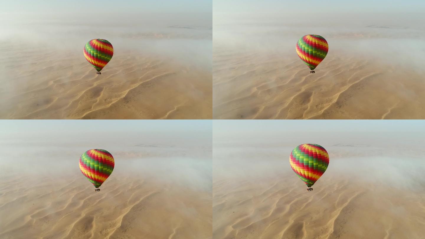 沙漠上热气球在云层中飞行的鸟瞰图。