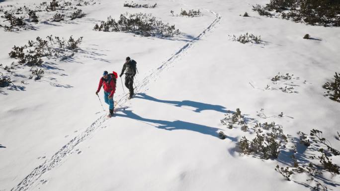 阳光明媚的冬日登山穿越山谷的航拍镜头