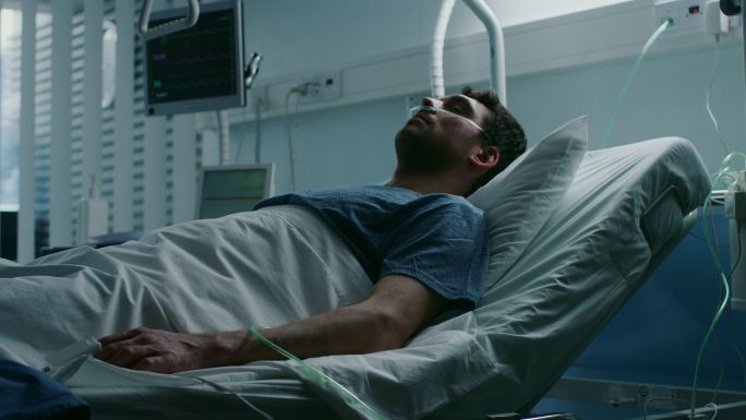 在医院里，一个病入膏肓的人躺在床上受苦