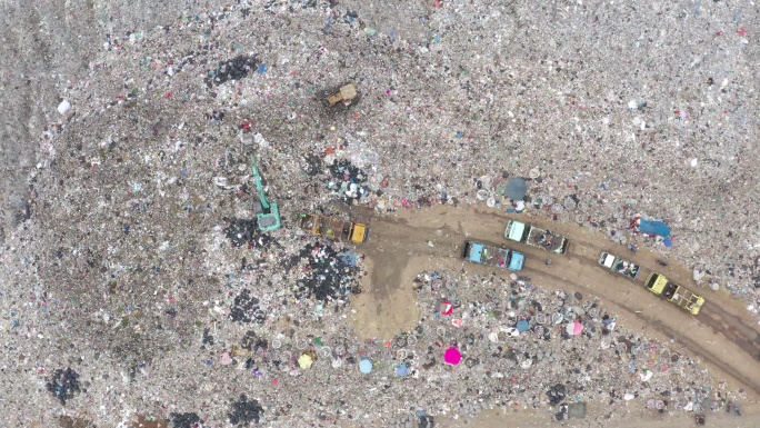 鸟瞰垃圾车将垃圾卸到垃圾填埋场。