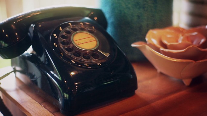 老式电话放在靠近窗户的木桌上