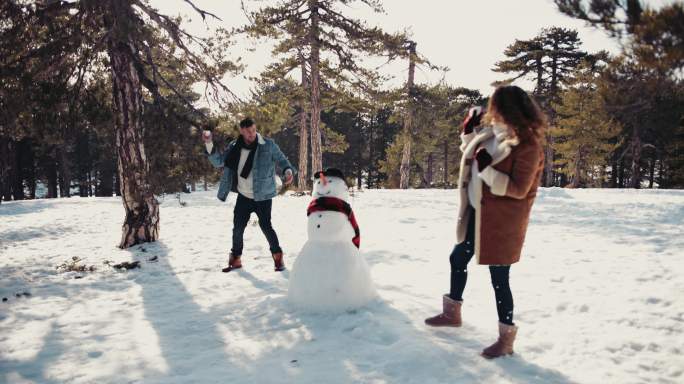 夫妇在雪地里玩打雪仗