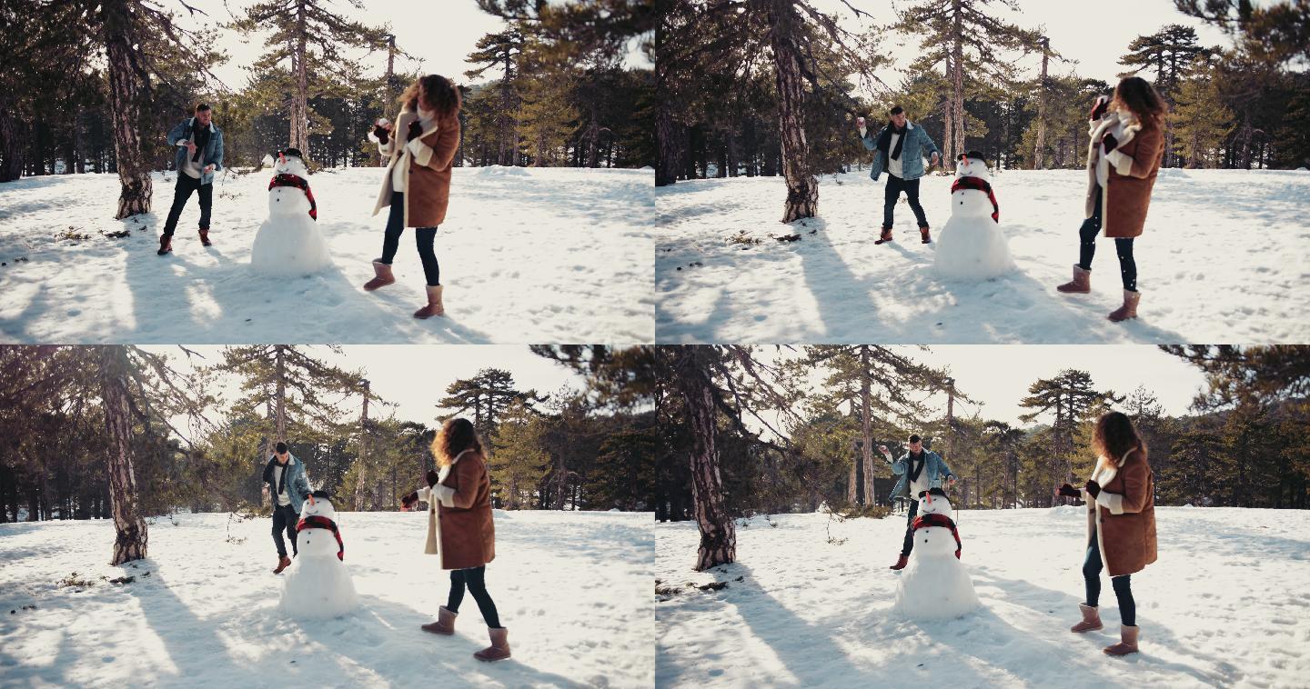 夫妇在雪地里玩打雪仗
