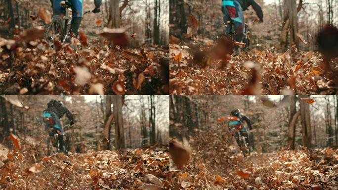山地摩托车手在森林小道上使树叶飞到空中