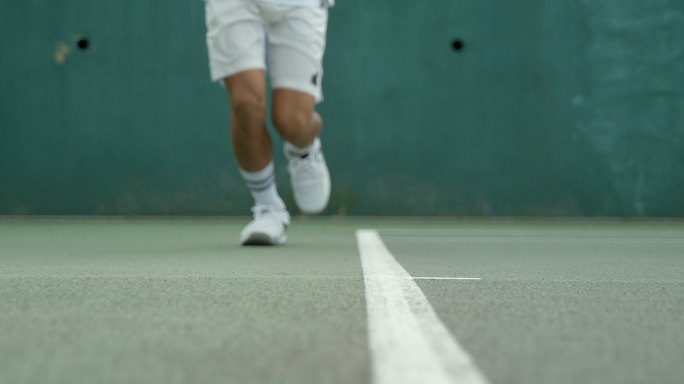 网球运动员在底线外击球。