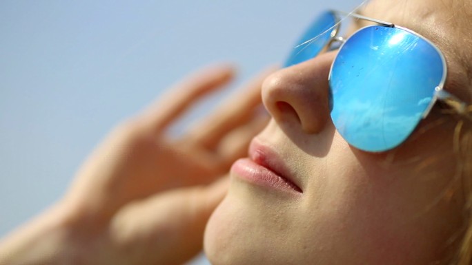 戴墨镜的女孩休闲旅游阳光沙滩太阳镜特写看