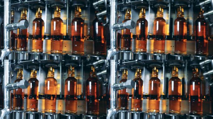 在工厂的工作机器上装满酒精的瓶子