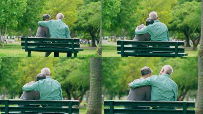 一对老年夫妇坐在公园长凳上的镜头