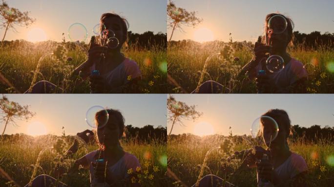 一个女孩日落时在草地上吹泡泡的慢镜头