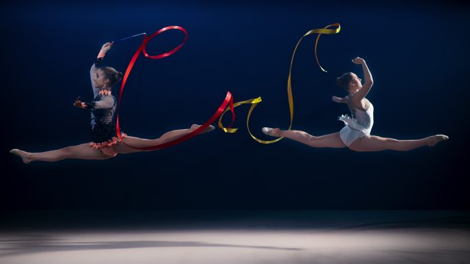 两名艺术体操运动员表演劈叉跳跃