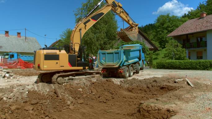 工地上的挖土机正在给卡车装土