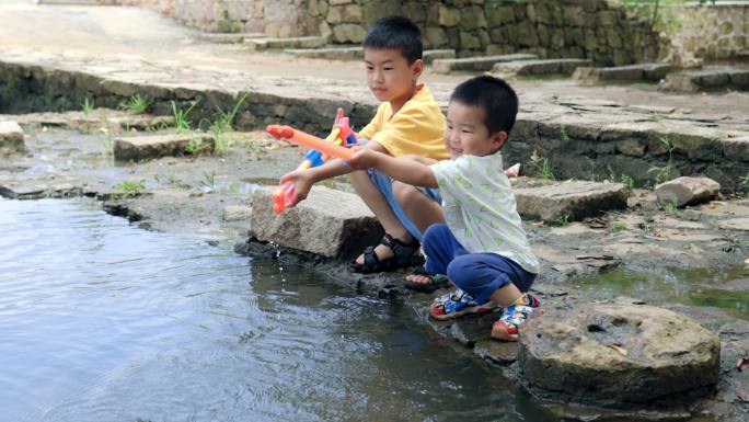 4K夏天河边玩水枪的兄弟俩