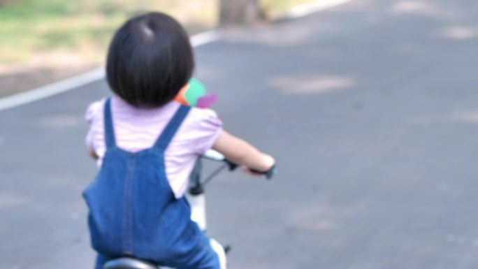 小女孩在的公园里骑自行车