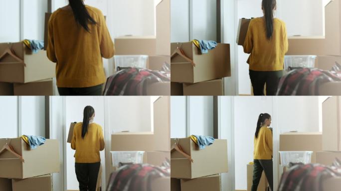 一个女人把装东西的纸板箱带进了她的新公寓
