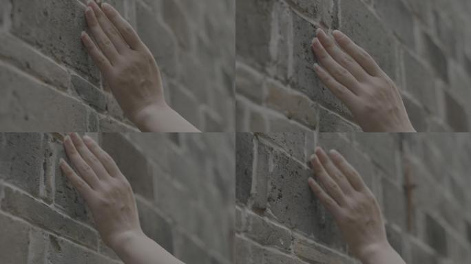 实拍美女手指抚过砖墙