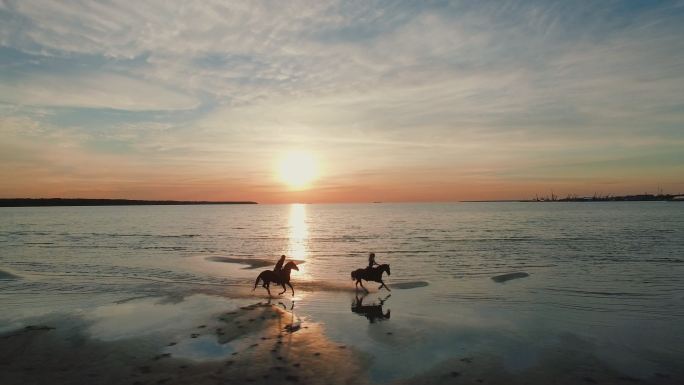 两个女孩在海滩上骑马