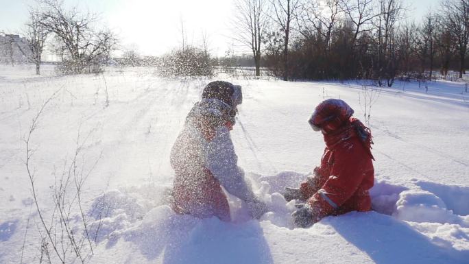 两个孩子一起玩雪撒雪打闹嬉戏