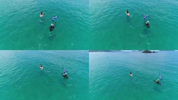在海面上划皮划艇的三个人