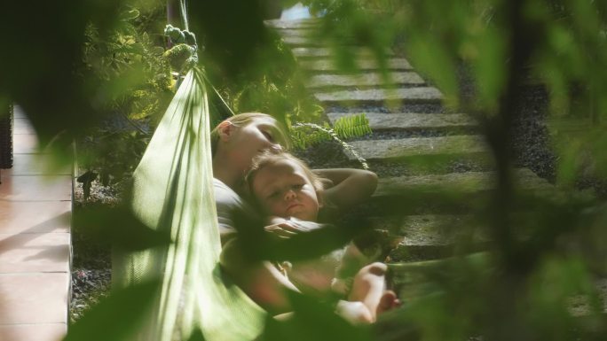 夏日，快乐的母女俩在花园的吊床上一起放松