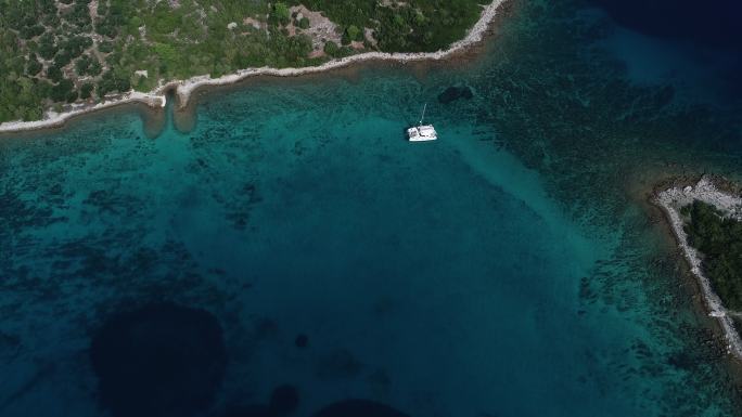 地中海小岛附近停泊的双体船鸟瞰图